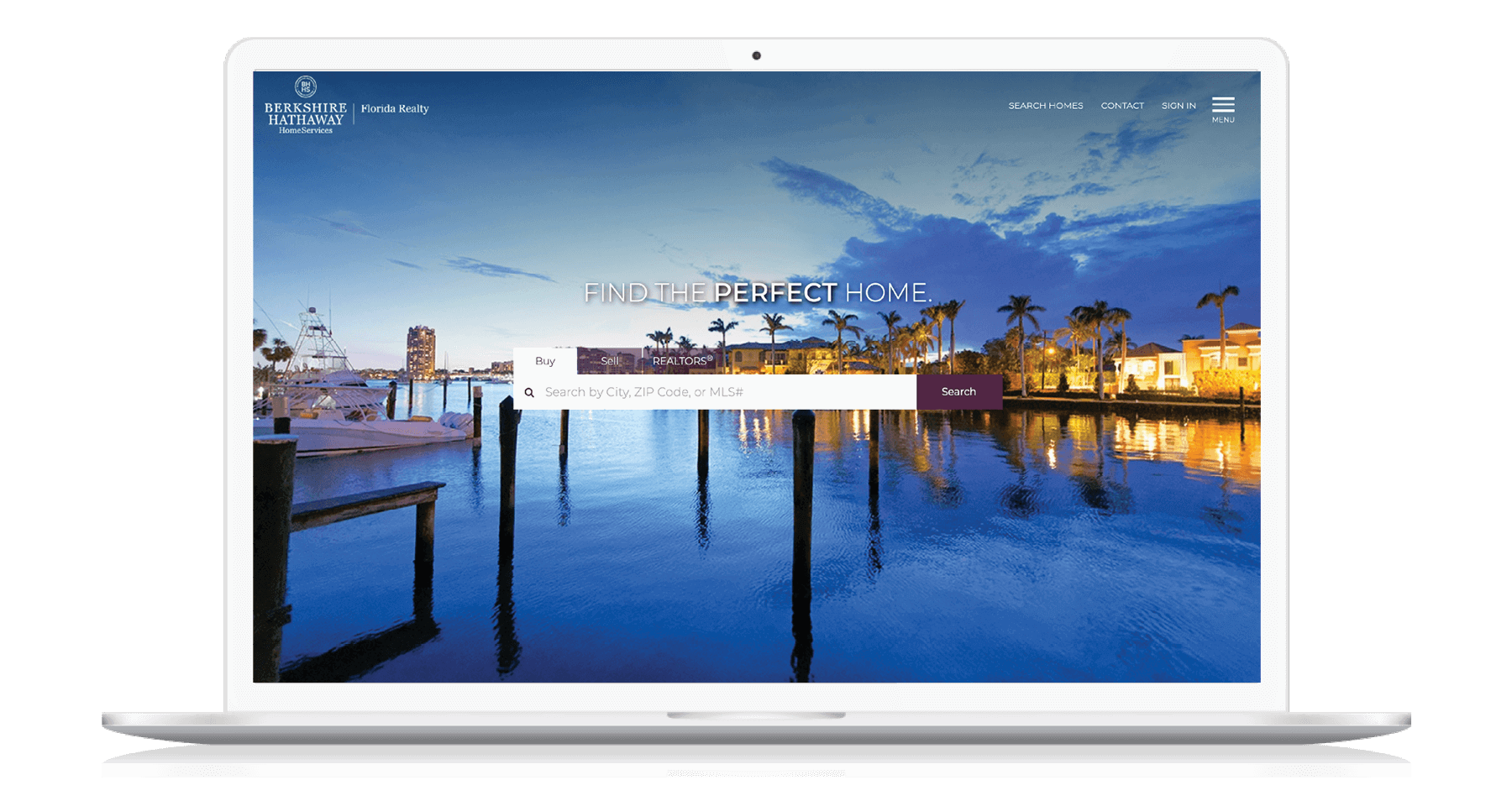 A laptop displaying the BHHS Florida Realty homepage, showing waterfront properties for sale in Florida at dusk.